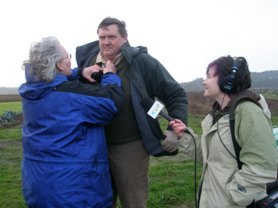 Cooking Up a Story Featured Rebecca Gerendasy of Cooking Up a Story, places a mic on farmer Anthony Boutard as OPB's April Baer looks on