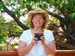 Lisa Bell, TwoJunes holding a seed tomato plant