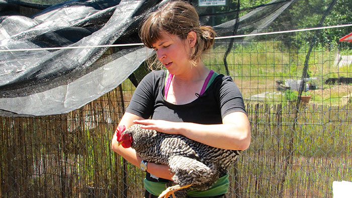 Naomi Montacre holding one of her chickens - Cooking Up a Story