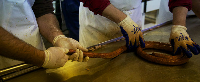 Ground pork being filled into the skin casings to form the sausage.